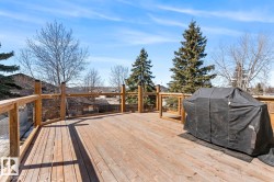 Expansive wood deck with natural wood railings, offering substantial outdoor living space - 