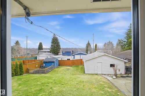 Expansive green lawn with a wood fence enclosure - 23 Clearwater, Devon, AB - Outdoor With Exterior