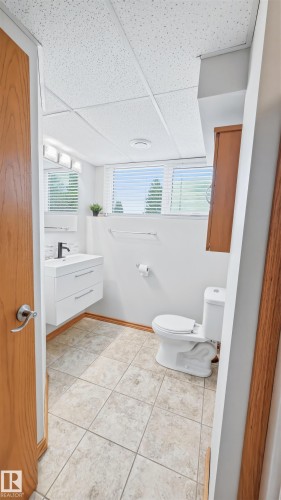 Bathroom featuring a floating white vanity with a rectangular sink, black faucet, and modern hardware - 23 Clearwater, Devon, AB - Indoor Photo Showing Bathroom