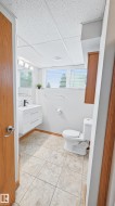 Bathroom featuring a floating white vanity with a rectangular sink, black faucet, and modern hardware - 