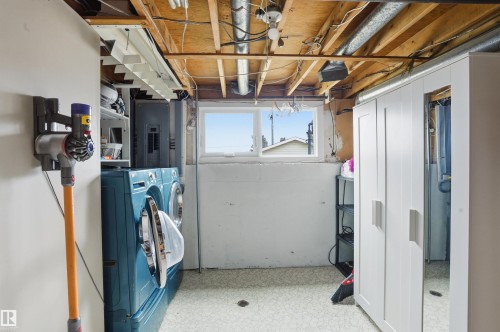 Laundry area featuring a side-by-side washer and dryer, painted white walls, and a window providing natural light - 23 Clearwater, Devon, AB - Indoor