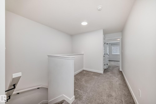 Upper-level landing featuring carpet flooring and white walls - 38 1910 Collip View, Edmonton, AB - Indoor Photo Showing Other Room