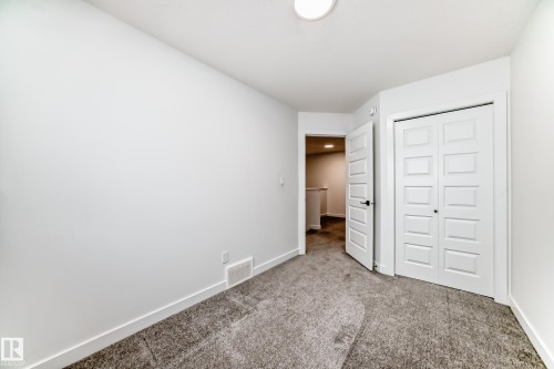 Neutral tone carpeting and white baseboards - 38 1910 Collip View, Edmonton, AB - Indoor Photo Showing Other Room