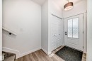 Entryway featuring wood-finish flooring, a contemporary pendant light fixture, a paneled front door with decorative glass, and bi-fold closet doors - 38 1910 Collip View, Edmonton, AB  - Indoor Photo Showing Other Room 