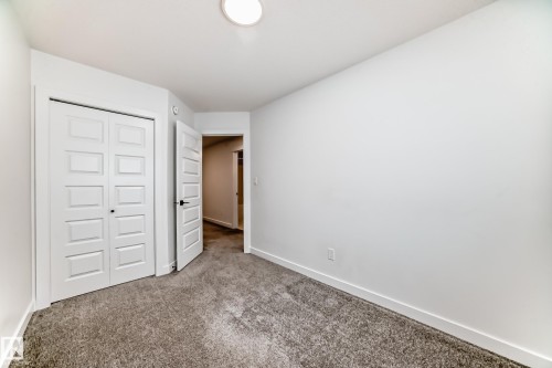 Neutral-toned room with plush carpeting, crisp white walls, and a recessed ceiling light - 38 1910 Collip View, Edmonton, AB - Indoor Photo Showing Other Room