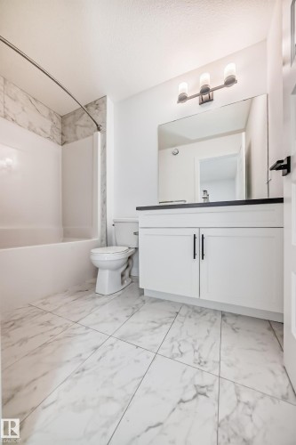 Bathroom featuring a white vanity with black hardware, a dark countertop, and an integrated sink - 38 1910 Collip View, Edmonton, AB - Indoor Photo Showing Bathroom