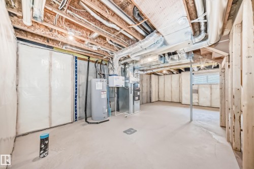 Unfinished basement featuring exposed wood joists, concrete flooring, a water heater, and a small window - 38 1910 Collip View, Edmonton, AB - Indoor Photo Showing Basement