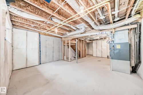 Unfinished basement area featuring concrete flooring, exposed ceiling joists, framed walls, and an HVAC system - 38 1910 Collip View, Edmonton, AB - Indoor Photo Showing Basement