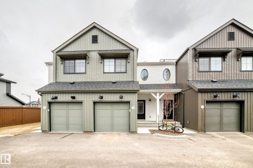 Modern multi-family dwelling featuring a two-car garage, board and batten siding, and a covered porch entry - 38 1910 Collip View, Edmonton, AB - Outdoor