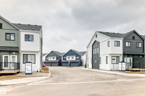 Contemporary townhome facade with mixed siding, black-framed windows, a private ground-level deck, and dark shingle roofing - 38 1910 Collip View, Edmonton, AB - Outdoor With Facade