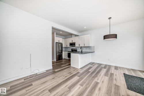 Open-concept living space featuring wood-finish flooring - 38 1910 Collip View, Edmonton, AB - Indoor Photo Showing Kitchen