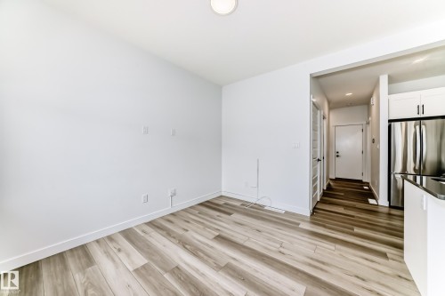 Open-concept living space featuring wood-finish flooring, white walls, and recessed lighting - 38 1910 Collip View, Edmonton, AB - Indoor Photo Showing Other Room