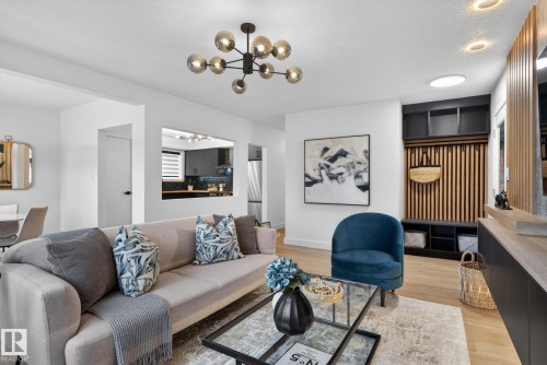 Open-concept living area with light wood-finish flooring, a contemporary chandelier, and recessed lighting - 13332 106 Street, Edmonton, AB - Indoor Photo Showing Living Room