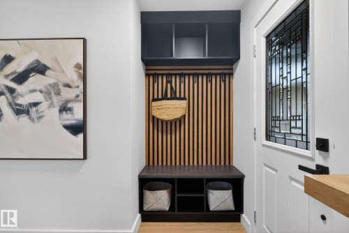 Entryway featuring a built-in storage bench with cubbies, wood-slat paneling, and an overhead shelf - 13332 106 Street, Edmonton, AB - Indoor Photo Showing Other Room