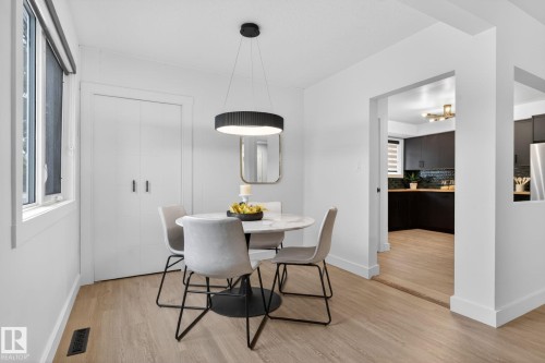 Dining area featuring wood-finish flooring and a contemporary pendant light fixture - 13332 106 Street, Edmonton, AB - Indoor Photo Showing Dining Room