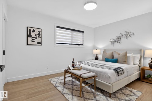 Well-lit interior space featuring wood-finish flooring, white baseboards, and a window with horizontal blinds - 13332 106 Street, Edmonton, AB - Indoor Photo Showing Bedroom