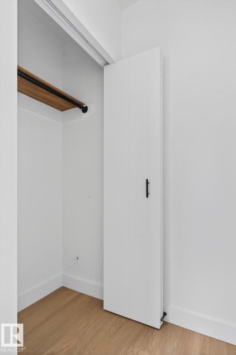 Light wood-finish flooring with crisp white baseboards - 13332 106 Street, Edmonton, AB - Indoor Photo Showing Other Room