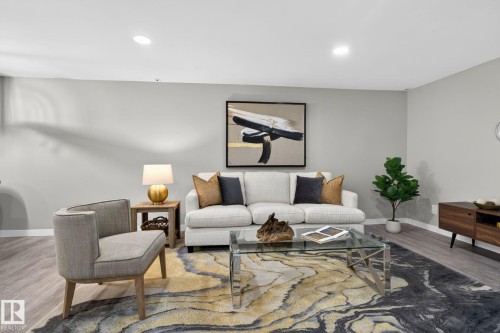 Recessed ceiling lighting illuminates a spacious room featuring light gray wall paint and wood-finish flooring - 13332 106 Street, Edmonton, AB - Indoor Photo Showing Living Room