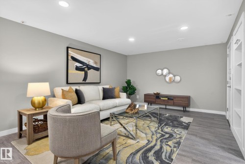 Open-concept living space featuring wood-finish flooring, recessed lighting, and built-in shelving - 13332 106 Street, Edmonton, AB - Indoor Photo Showing Living Room