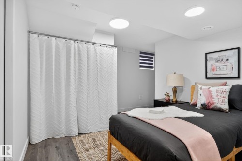 Bedroom featuring wood-finish flooring, recessed ceiling lights, and a window with horizontal blinds - 13332 106 Street, Edmonton, AB - Indoor Photo Showing Bedroom