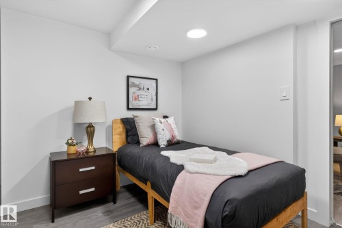 Light-filled room featuring recessed ceiling lighting, a wood-finish bed frame, and a dark wood-finish nightstand with silver hardware - 13332 106 Street, Edmonton, AB - Indoor Photo Showing Bedroom