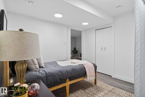 Room featuring wood-finish flooring, recessed lighting, white walls, and bi-fold closet doors - 13332 106 Street, Edmonton, AB - Indoor Photo Showing Bedroom