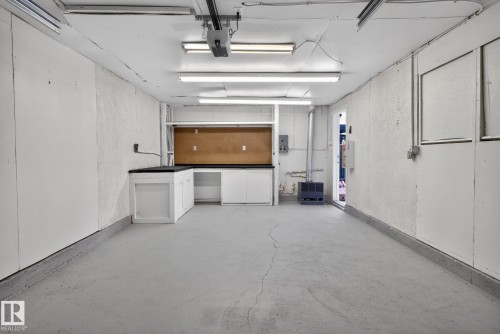 Spacious garage featuring a durable concrete floor and fluorescent lighting - 13332 106 Street, Edmonton, AB - Indoor Photo Showing Garage