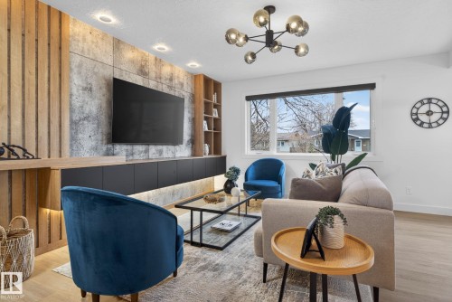 Living area featuring a textured accent wall with wood paneling and concrete-finish sections - 13332 106 Street, Edmonton, AB - Indoor