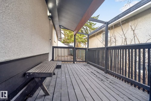 Covered outdoor deck with dark-stained wood flooring and railing - 13332 106 Street, Edmonton, AB - Outdoor With Deck Patio Veranda With Exterior