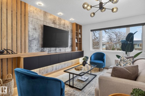 Custom media wall featuring wood slat and concrete-finish panels, integrated shelving, and a floating cabinet with under-cabinet lighting - 13332 106 Street, Edmonton, AB - Indoor