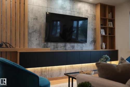 Feature wall with concrete-finish paneling and vertical wood-slat accents - 13332 106 Street, Edmonton, AB - Indoor Photo Showing Other Room