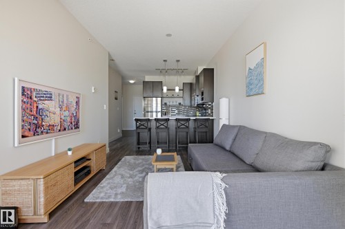Open-concept living space featuring wood-finish flooring and light neutral wall tones - 403 10418 81 Avenue, Edmonton, AB - Indoor Photo Showing Living Room