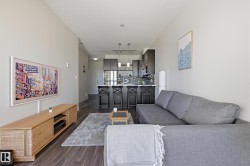 Open-concept living space featuring wood-finish flooring and light neutral wall tones - 