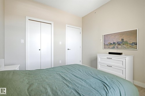 Neutral-toned bedroom featuring a white bi-fold closet and a matching white interior door - 403 10418 81 Avenue, Edmonton, AB - Indoor Photo Showing Bedroom