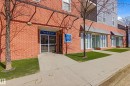 Brick exterior featuring a main entrance with glass doors, a concrete sidewalk, and landscaped green spaces - 403 10418 81 Avenue, Edmonton, AB  - Outdoor 