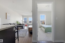 Open concept living area with wood-finish flooring and a kitchen island featuring a light-toned countertop - 
