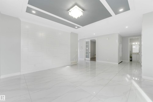 Expansive room featuring large format tile flooring and a decorative accent wall - 3736 1 Avenue Sw, Edmonton, AB - Indoor Photo Showing Other Room