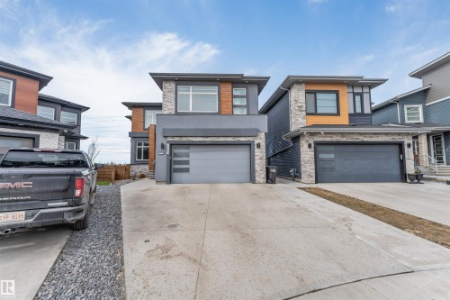 Modern architectural style featuring a multi-textured facade with stone, wood-finish paneling, and stucco - 3736 1 Avenue Sw, Edmonton, AB - Outdoor With Facade