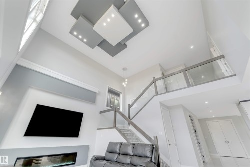 Vaulted ceiling featuring a multi-level decorative light fixture - 3736 1 Avenue Sw, Edmonton, AB - Indoor With Fireplace