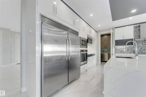 Gourmet kitchen featuring a large stainless steel refrigerator, built-in microwave, and oven - 3736 1 Avenue Sw, Edmonton, AB - Indoor Photo Showing Kitchen With Upgraded Kitchen