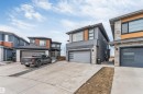 Contemporary exterior featuring a flat roofline, dark grey stucco, stone veneer accents, and light wood-tone siding - 3736 1 Avenue Sw, Edmonton, AB  - Outdoor With Facade 