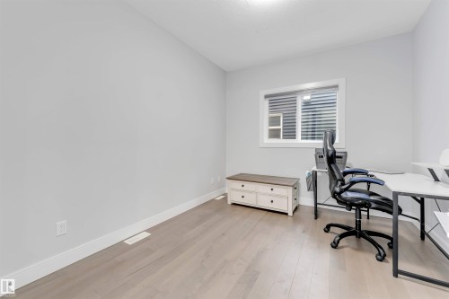 Spacious room featuring light wood-finish flooring, white baseboards, and neutral wall tones - 3736 1 Avenue Sw, Edmonton, AB - Indoor Photo Showing Office