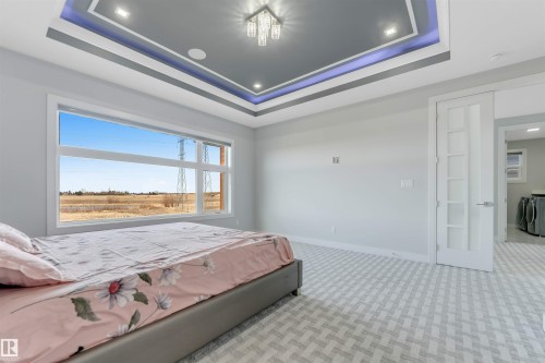 Tray ceiling with recessed lighting and a central chandelier - 3736 1 Avenue Sw, Edmonton, AB - Indoor Photo Showing Bedroom