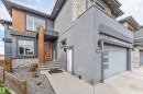 Contemporary exterior featuring a smooth stucco finish, natural wood-look paneling, and stacked stone accents - 3736 1 Avenue Sw, Edmonton, AB  - Outdoor 
