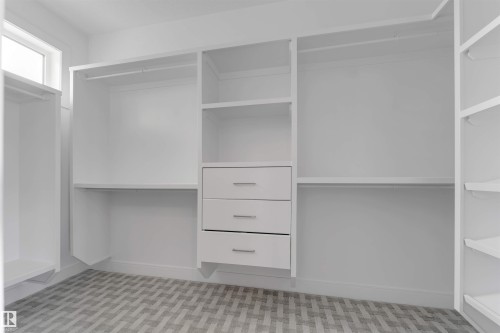 Custom closet system featuring multiple hanging rods, open shelving, and built-in drawers - 3736 1 Avenue Sw, Edmonton, AB - Indoor With Storage