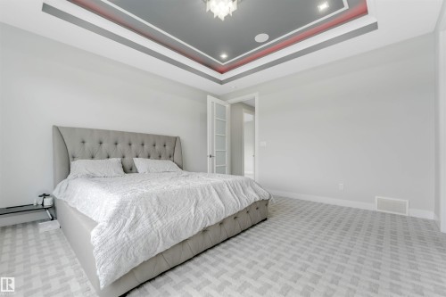 Tray ceiling with accent lighting, recessed lighting, and a modern ceiling fixture - 3736 1 Avenue Sw, Edmonton, AB - Indoor Photo Showing Bedroom