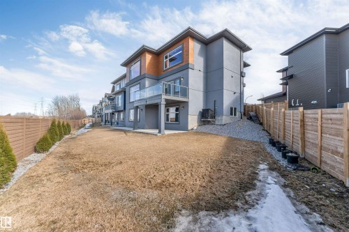 Multi-level exterior featuring grey stucco and wood-tone paneling - 3736 1 Avenue Sw, Edmonton, AB - Outdoor