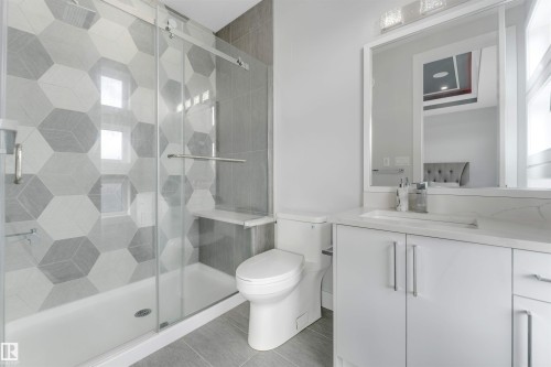 Bathroom featuring a glass-enclosed tub and shower with hexagon-patterned tile surround - 3736 1 Avenue Sw, Edmonton, AB - Indoor Photo Showing Bathroom