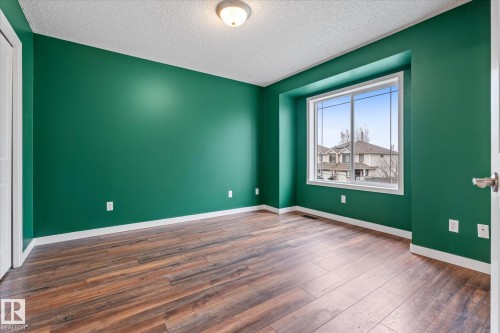 Bright interior space featuring wood-finish flooring, vibrant green walls, and white trim - 5407 204 Street, Edmonton, AB - Indoor Photo Showing Other Room