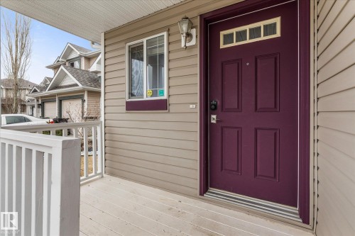 Front entry with a deep purple door, transom window, and paneled siding exterior - 5407 204 Street, Edmonton, AB - Outdoor With Exterior